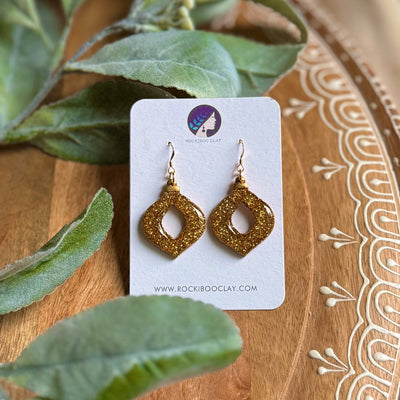 Handmade Christmas earrings with golden shimmer showcasing stunning design.